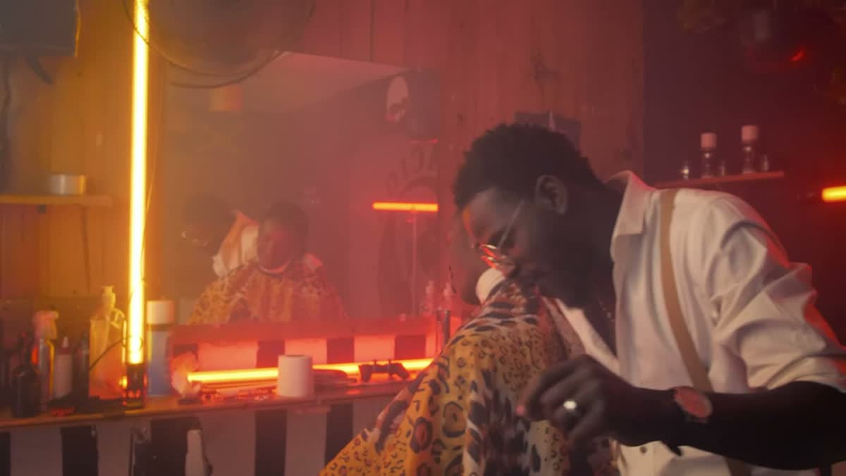 A barber working in a warmly lit shop